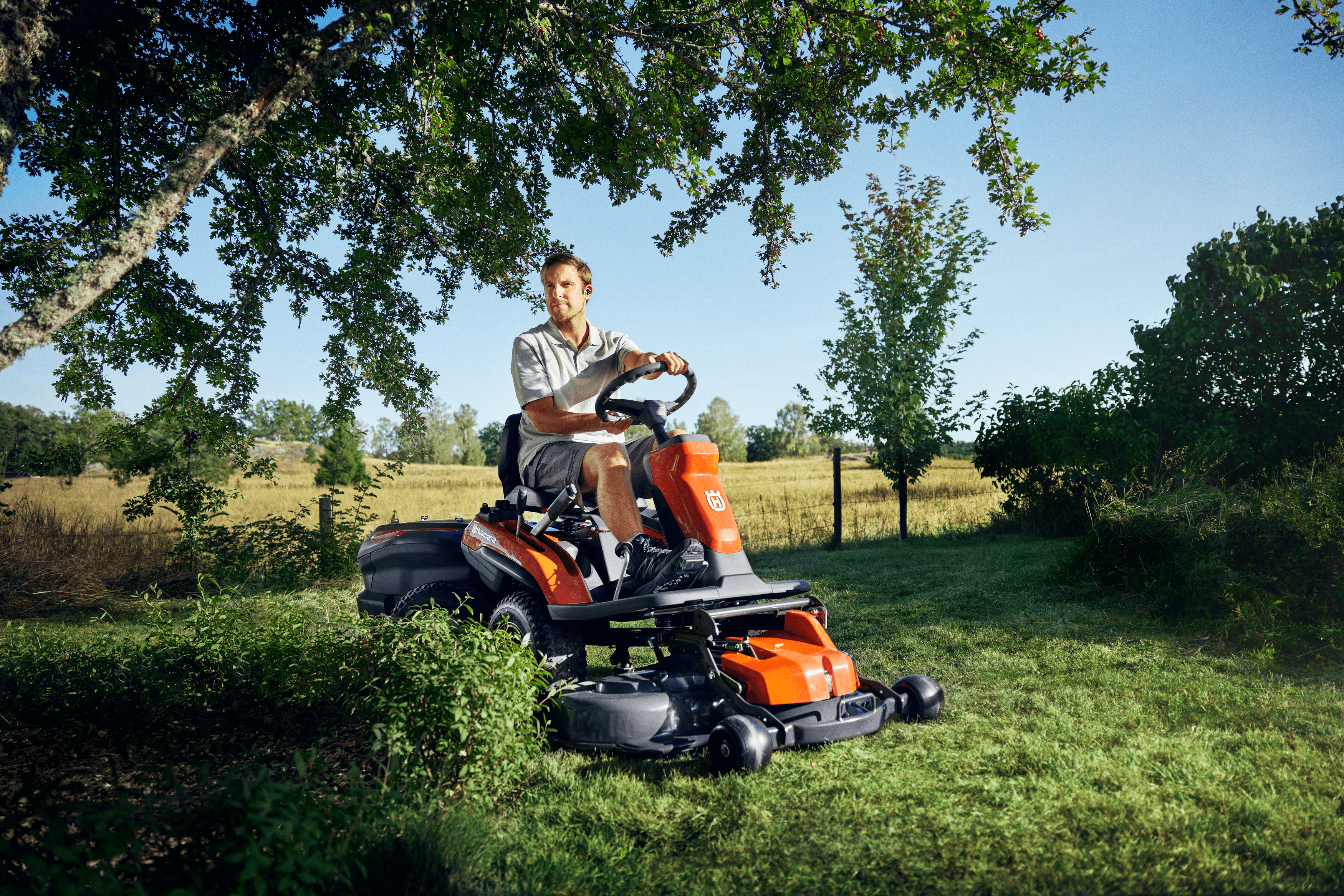 Man wearing range of personal protective equipment while using chainsaw on tree